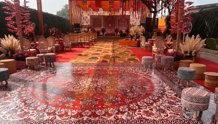 Illuminated wedding stage backdrop with floral and lighting design by TVD Global